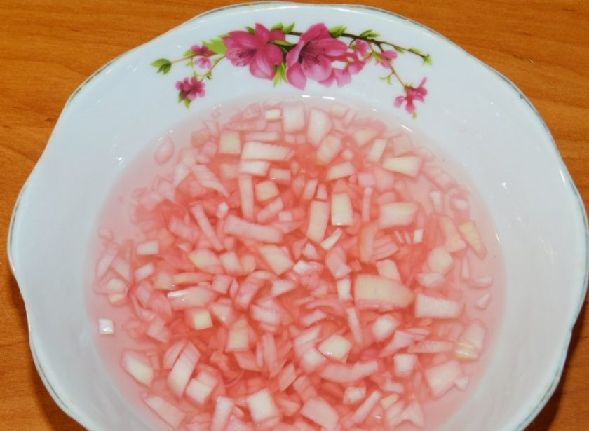 1. Этап. Овощной салат с колбасой: Первым делом замаринуйте лук. Для этого его мелко нарежьте и залейте уксусом наполовину с водой. Дайте постоять минут 15. Затем жидкость необходимо слить.