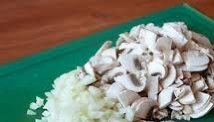 1. Этап. Постные вареники с грибами: В это время приготовьте начинку. Лук почистите и нарежьте на небольшие кубики. Грибы нарежьте на пластинки, каждую из которых затем разрежьте еще напополам.