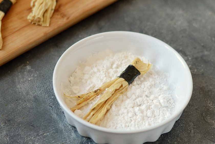 1. Этап. Жареная соевая спаржа: Обваляйте спаржу в крахмале.