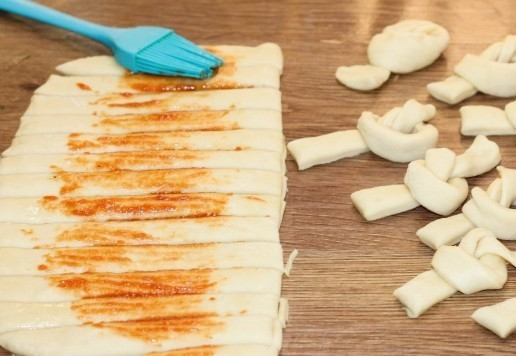 1. Этап. Морские узелки с чесночным маслом: 10. Затем нарежьте пласт небольшими полосками. Завяжите узелки из каждой полоски.