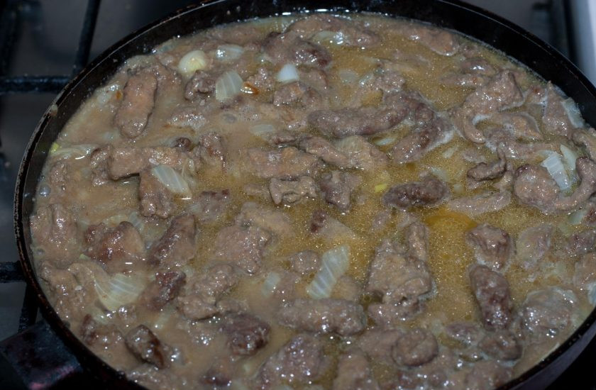 1. Этап. Печень говяжья по-строгановски: В сковороду влейте кипяченую воду или бульон, убавьте огонь до минимума и оставьте тушиться 8-10 минут.