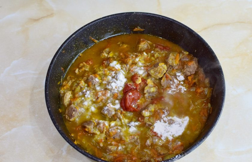 1. Этап. Лосятина с киви: Когда мясо будет почти готово, посыпьте его мукой через ситечко. Добавьте томатную пасту. По вкусу подсолите и добавьте специи. Все смешайте.