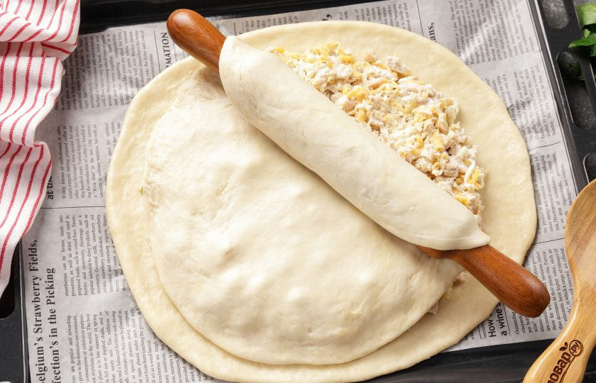 1. Этап. Бездрожжевой пирог с курицей: Раскатайте меньшую часть теста и при помощи скалки перенесите на пирог.