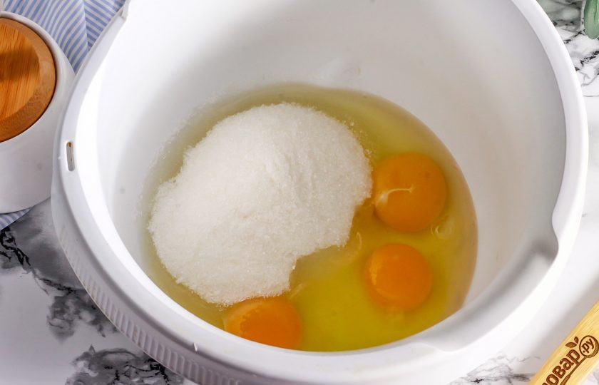 1. Этап. Десерт Панчо в стакане: Вбейте куриные яйца в чашу кухонного комбайна. Всыпьте 150 грамм сахара и соль. Взбейте примерно 3-5 минуты в пышную пену.