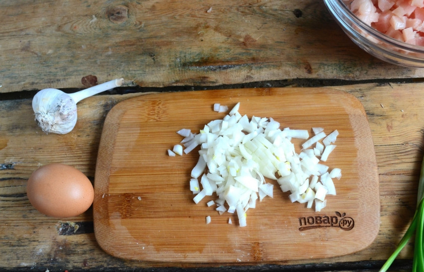 1. Этап. Нежные куриные шарики в сливочном соусе: Луковицу мелко порубите. Если вы измельчаете куриную грудку в кухонном комбайне, то вместе с ней измельчите и луковицу.