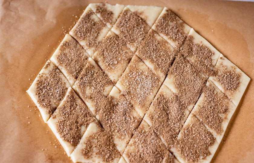 1. Этап. Печенье Земелах с корицей: Затем охлажденное тесто раскатайте прямо на пергаменте для выпекания в пласт толщиной примерно в 0,5 см. Ножом нарежьте пласт теста на ромбы и каждый ромб обильно присыпьте смесью корицы и сахара (20 грамм). Отправьте печенье выпекаться в уже разогретую до 180 градусов духовку на 15-20 минут.