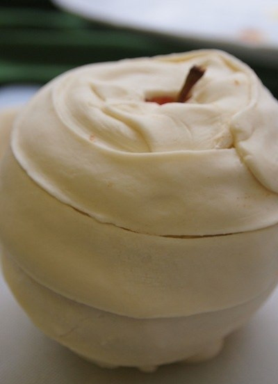 1. Этап. Запеченное яблоко в слоеном тесте: В сердцевину яблока вставляем карамельку. Из слоеного теста вырезаем полоски, которыми аккуратненько оборачиваем яблоко.