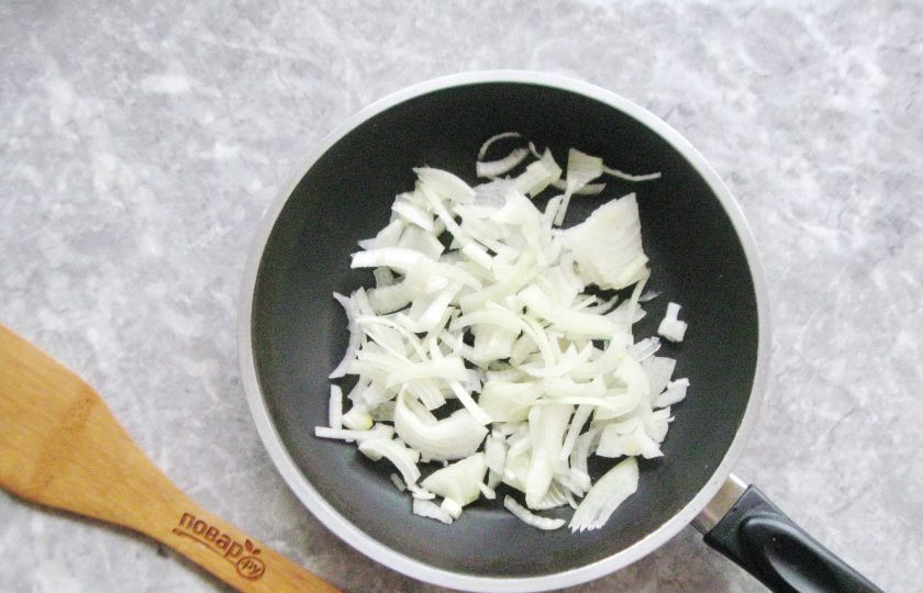 1. Этап. Куриная печень с луком и белым вином: Репчатый лук очистите, промойте и нарежьте полукольцами. Выложите в сковороду с маслом.