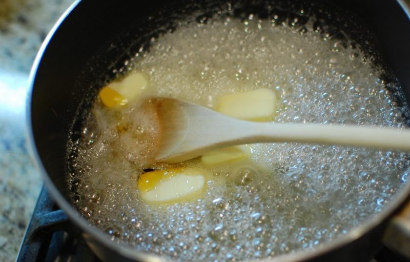 1. Этап. Домашняя помадка: 2. Добавьте в казанок сливочное масло и кукурузный или золотой сироп, перемешайте и варите до растворения, перемешивая деревянной лопаткой.