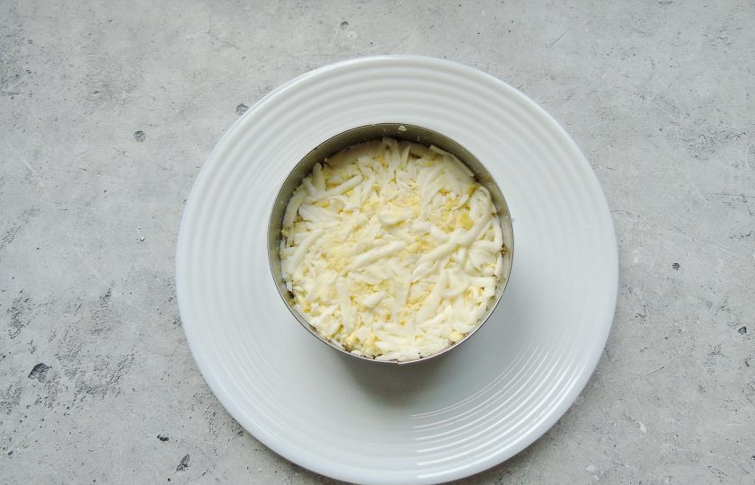 1. Этап. Слоеный салат Лесная поляна с маринованными опятами: Яйца сварите вкрутую, охладите, очистите. Натрите на терке и выложите третьим слоем. Смажьте майонезом.