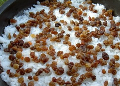 1. Этап. Плов с курагой и изюмом: В сковороду с луком добавить измельченный чеснок и курагу. Обжаривать, помешивая 1-2 минуты, после чего выложить рис, поверх него - высыпать изюм. Залить бульоном, посолить, посыпать специями и готовить на медленном огне под крышкой, пока рис не впитает всю жидкость.