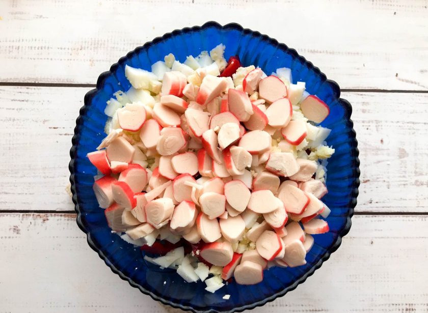 1. Этап. Салат Солнечный зайчик: Крабовые палочки мелко нарежьте.