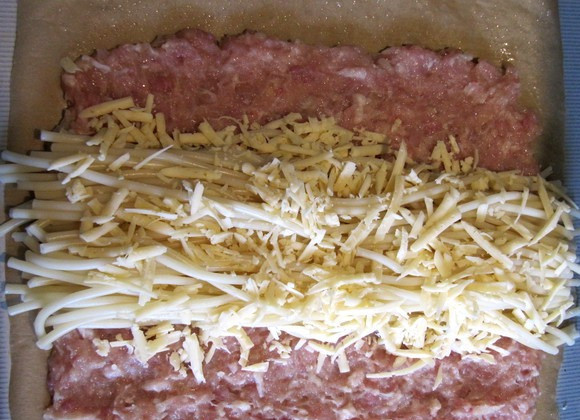 1. Этап. Запеканка мясная с макаронами: Фарш смешиваем с яйцо и измельченным луком и чесноком, солим и перчим его, макароны аккуратно, чтобы не повредить, отвариваем в слегка подсоленной воде до полуготовности. Теперь смазываем бумагу для выпечки растительным маслом и выкладываем на нее фарш в виде прямоугольника. По середине прямоугольника кладем макароны и посыпаем их тертым сыром.