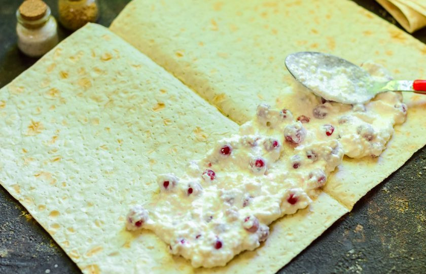 1. Этап. Рулет из лаваша с ягодами и творогом: Разложите лаваш на рабочей поверхности. По краю лаваша выложите творожную начинку.