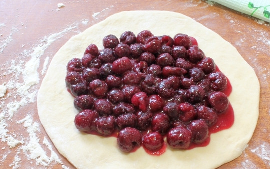 1. Этап. Осетинский пирог Балджин: Выкладывайте вишню на центр лепешки, посыпьте ее сахаром.