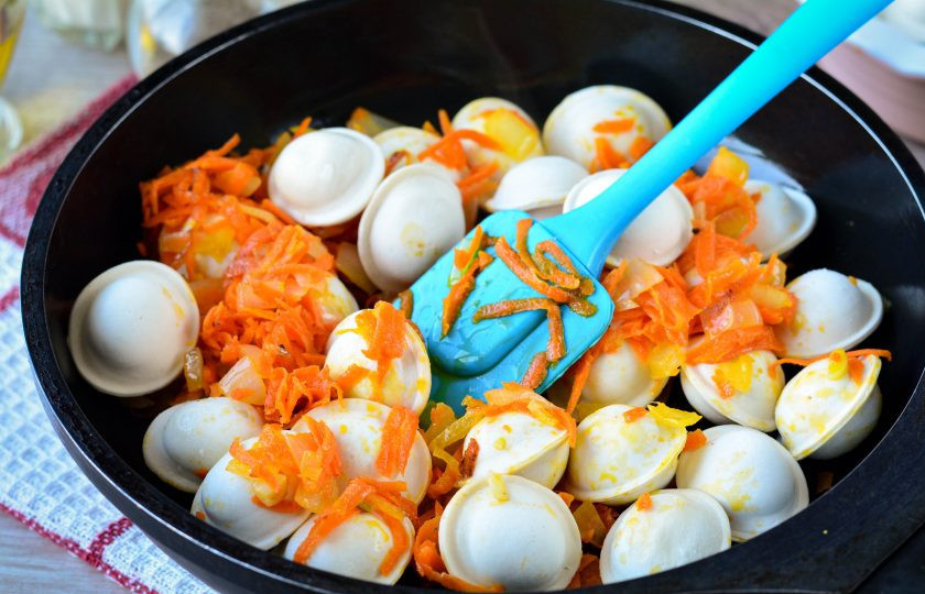 1. Этап. Пельмени тушеные с морковью и луком: Всыпьте пельмени и перемешайте.