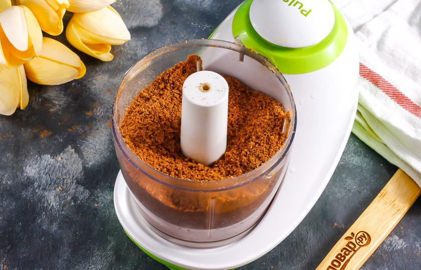 1. Этап. Шоколадный медовик: Разломите оставшиеся коржи и поместите в чашу измельчителя. Пробейте в крошку примерно 2-3 минуты.