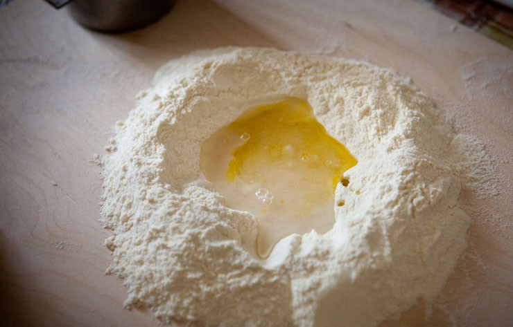 1. Этап. Орекьетте: 1. На рабочий стол высыпьте просеянную муку и манку, сделайте в центре углубление и влейте теплую воду и масло. Тщательно перемешайте, замесите тесто, скатайте в шарик и дайте отдохнуть минут 15.