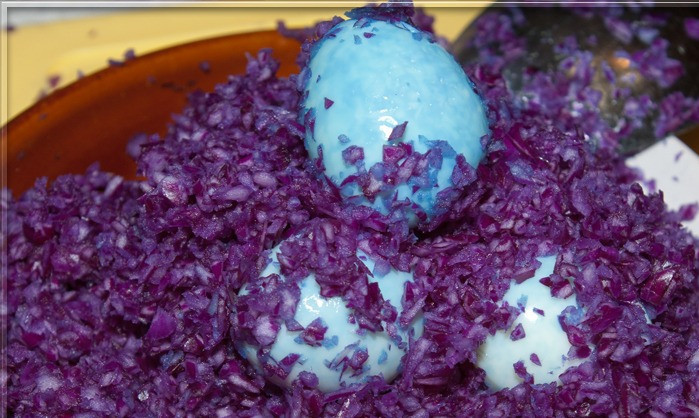 1. Этап. Салат Снегурочка: 6. Шинкуем заранее мелко капусту и жмем ее руками. Как только она пустит немного сока, отправляем в нее белки, чтобы они окрасились. Затем даем им немного полежать и натираем на терке - это будет наша 