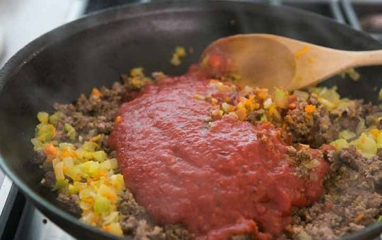 1. Этап. Бургер Неряшливый Джо: 5. Выложите к фаршу ранее обжаренные овощи, добавьте кетчуп и томатный соус, вустерширский соус, винный уксус и сахарный песок, а также молотую гвоздику.