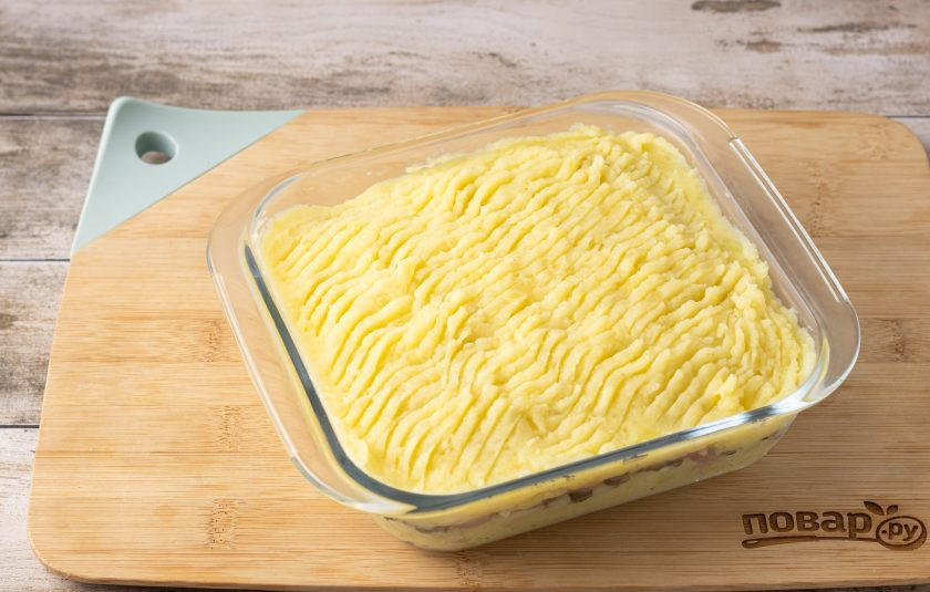 1. Этап. Картофельная запеканка с сосисками и грибами: Накройте второй половиной картофельного пюре. Запекайте в разогретой до 200 градусов духовке 15-20 минут.