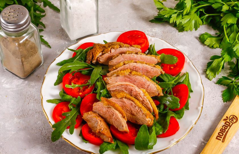 1. Этап. Салат с уткой и рукколой: Утиную грудку извлеките из фольги и нарежьте слайсами. Выложите на тарелку. Посолите и поперчите, сбрызните маслом, оставшимся от жарки грудки.