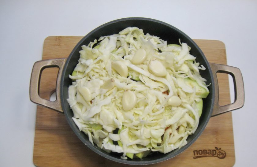 1. Этап. Басма в казане: Белокочанную капусту нарежьте соломкой и выложите верхним слоем. Добавьте чеснок.