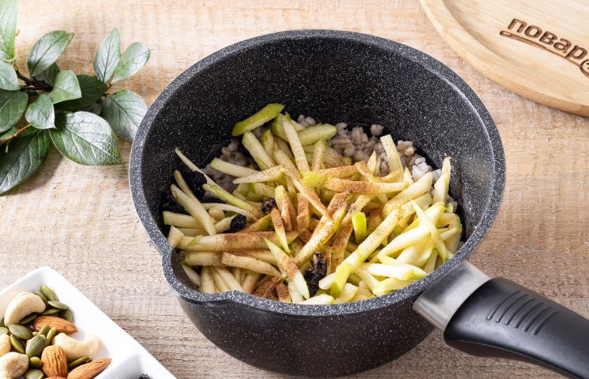 1. Этап. Сладкая перловая каша: Добавьте яблоко с изюмом в кашу, добавьте сахар и молотую корицу. Все перемешайте. Варите кашу еще минут 10-15 до полной готовности перловки.