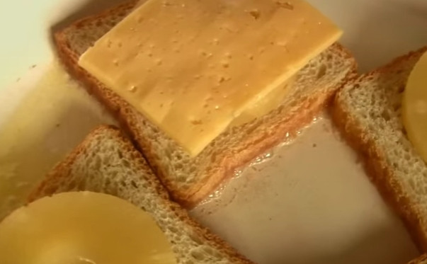 1. Этап. Бутерброды с сыром и ананасами: 4. Сыр нарежьте тоненькими пластинками. Выложите их поверх ананаса.