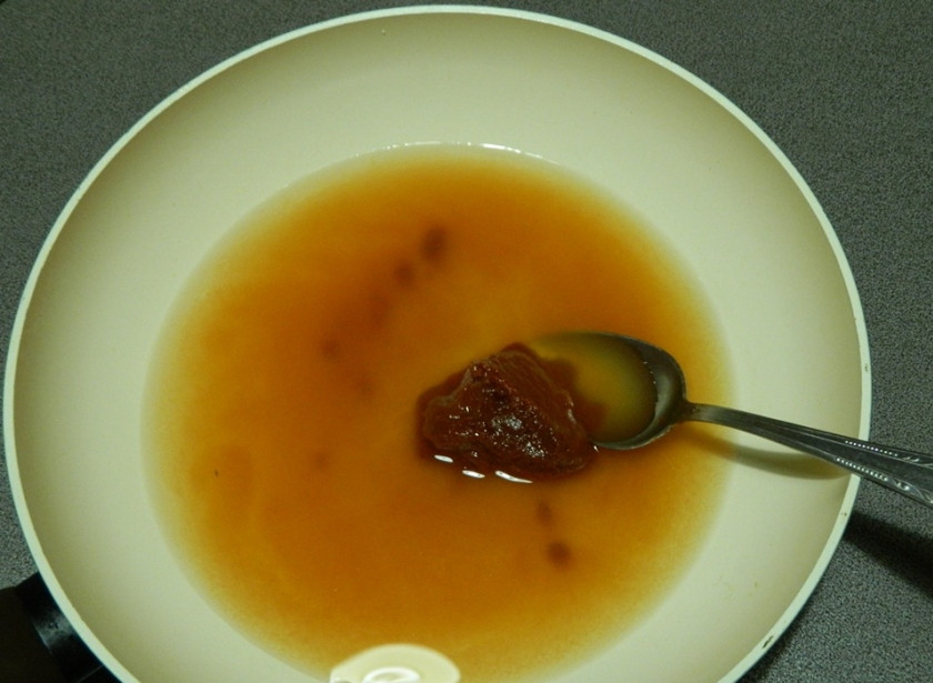 1. Этап. Лобио с орехами: Протушите томатную пасту с водой на сковороде.