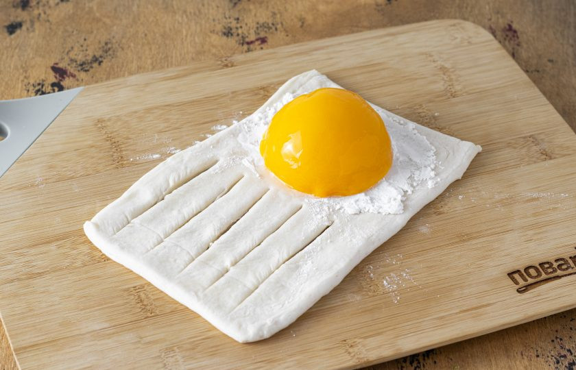 1. Этап. Слойки с консервированными персиками: Выложите на второй край половинку консервированного персика.