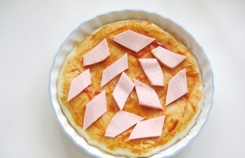 1. Этап. Пицца с колбасой и болгарским перцем: Выложите на тесто нарезанную колбасу.