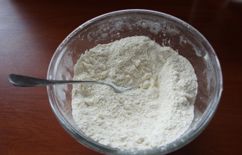 1. Этап. Печенье на кефире в духовке: Муку просеяться в миску дважды. Натрите на терке масло. Смешайте быстро руками масло с мукой до образования крошки.