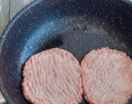 1. Этап. Двойной мясной бургер с карамелизированным луком: Сформировать четыре котлетки, обвалять в панировочных сухарях, переложить в сковороду, смазанную растительным маслом.