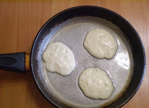 1. Этап. Дрожжевые оладьи на кефире: Разогрейте сковороду, влейте масло. Столовой ложкой осторожно с края набирайте тесто и выкладывайте в горячее масло.