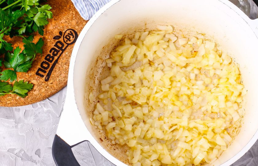 1. Этап. Баклажанная икра без уксуса: Очистите репчатый лук и промойте, нарежьте мелким кубиком. Отпассеруйте луковую нарезку в растительном масле, в казане примерно 2-4 минуты до румяности.