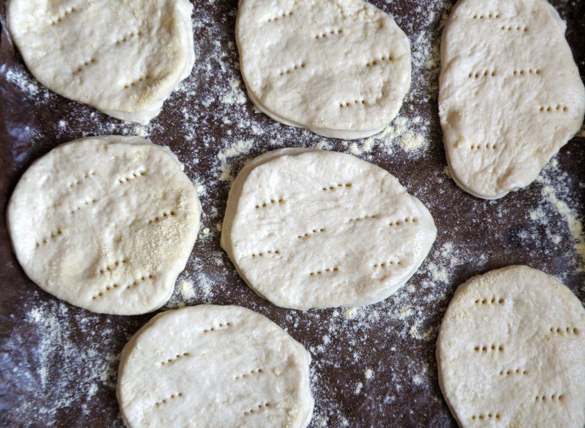 1. Этап. Нежные пшенные лепешки: Разложите лепешки на лист с пергаментом, наколите их вилкой. Немного присыпьте лепешки мукой. Дайте им подойти и выпекайте в разогретой до 200 градусов духовке до румяной корочки.