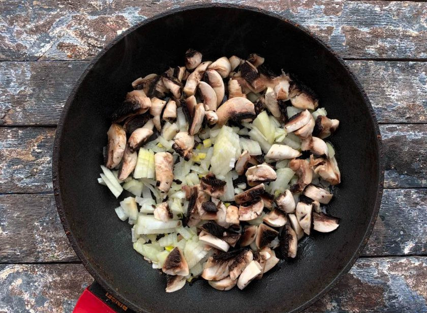 1. Этап. Фунчоза с копченой курицей: Лук очистите от шелухи и мелко нарежьте. Грибы хорошо промойте под проточной водой и нарежьте. Обжарьте грибы с луком на хорошо разогретой сковороде с небольшим количеством растительного масла в течение 7-10 минут.