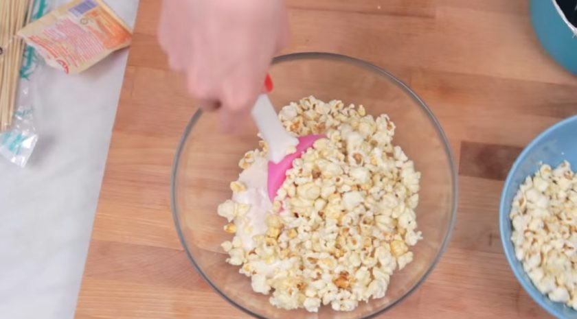 1. Этап. Шарики из попкорна с маршмеллоу: 3. Постоянно помешивая, доведите массу до загустения и дайте маршмеллоу полностью раствориться. Снимите массу с огня и добавьте к ней попкорн, постоянно перемешивая до однородного состояния.