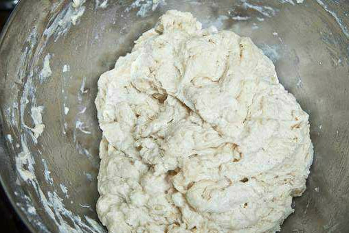 1. Этап. Тесто на пирожки жареные: Опара у нас подошла быстро, поскольку дрожжи у меня сухие. Теперь досыпаем всю оставшуюся муку через сито. Доливаем 200 мл теплой воды. Хорошенько перемешиваем все руками. После этого, наливаем 100 мл растительного масла. Тесто нужно вымесить так, чтобы оно хорошо отлипало от стенок посуды.