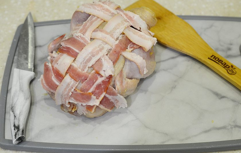 1. Этап. Курица, запеченная в беконе: 7.Бекон нарежьте полосками и выложите на грудку курицы.