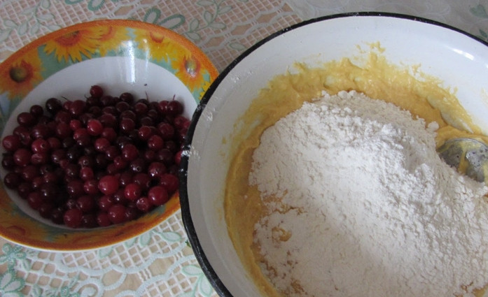 1. Этап. Клюквенный пирог простой: Просеиваем муку с разрыхлителем, постепенно вводим в тесто, перемешивая его. Ягоды промываем.