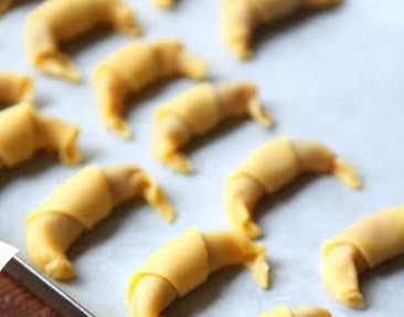 1. Этап. Рогалики из песочного теста: 2. Начав от толстого края треугольника, сверните рогалик. Концы склейте и загните. Выложите рогалики на застеленный пергаментом противень.