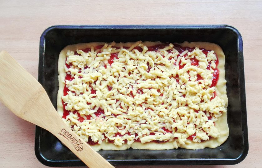 1. Этап. Песочный пирог с малиновым вареньем: Достаньте тесто из холодильника и натрите на терке прямо на варенье.