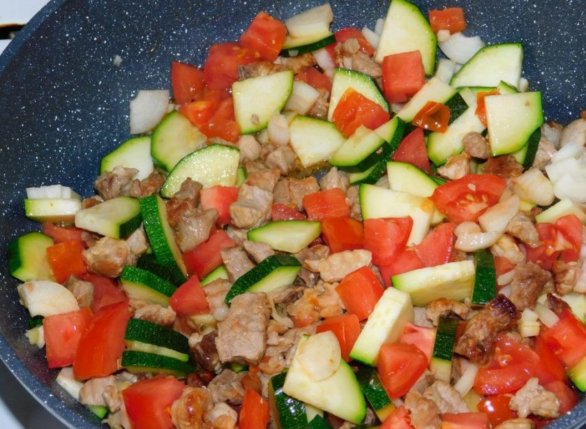 1. Этап. Мясной омлет с кабачками и помидорами: Добавьте нарезанный лук, помидоры и кабачки. Накройте крышкой и готовьте на небольшом огне минут 15.