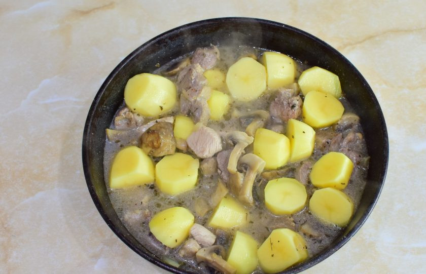 1. Этап. Индейка с шампиньонами и картошкой: Добавьте в сковороду картофель и подлейте горячую воду. По вкусу подсыпьте соль и специи. Накройте крышкой и тушите на небольшом огне 15-20 минут. Мясо полностью приготовится, а картофель станет мягкий. Воды можно добавить больше.