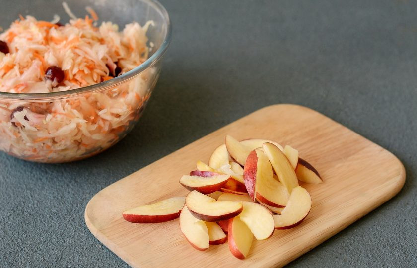 1. Этап. Квашеная капуста с клюквой и яблоками: Яблоко нарежьте тонкими дольками.