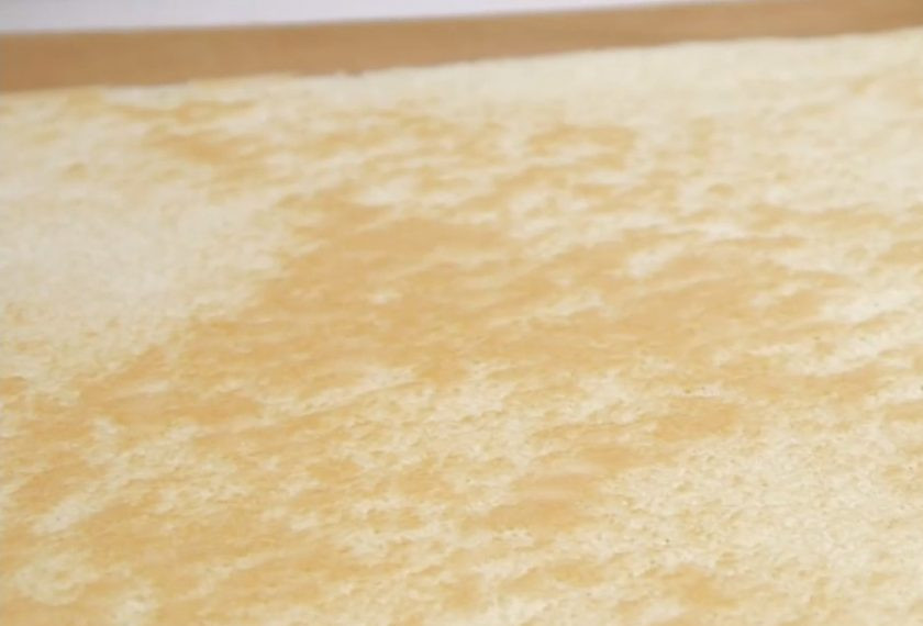 1. Этап. Бисквитный рулет с желе: 6. По одной ложке добавьте остывший сироп (оставьте часть сиропа для пропитки бисквита), тщательно взбивая после каждой. Коржи очистите от корочек и срежьте кромки. Пропитайте сиропом и оставьте на 10 минут. Желе разрежьте на полоски.