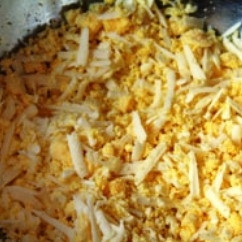 1. Этап. Яйца, фаршированные сыром и чесноком: Яйца отварим вкрутую, очистим, аккуратно разрежем пополам. Желтки натираем на крупной терке вместе с сыром и чесноком. По вкусу можно подсолить.