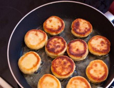 1. Этап. Сырники с вишневым соусом: 3. Немного масла наливаем в сковороду, разогреваем и выкладываем сюда сырники. На небольшом огне жарим до золотистого цвета. Обжариваем с обеих сторон.